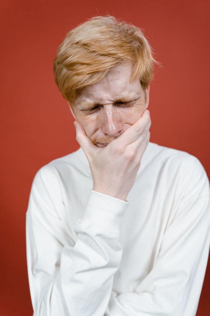 Homme se tenant la mâchoire, douleur dentaire